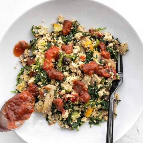 Salsa being spooned onto a bowl of Vegetable Tofu Scramble