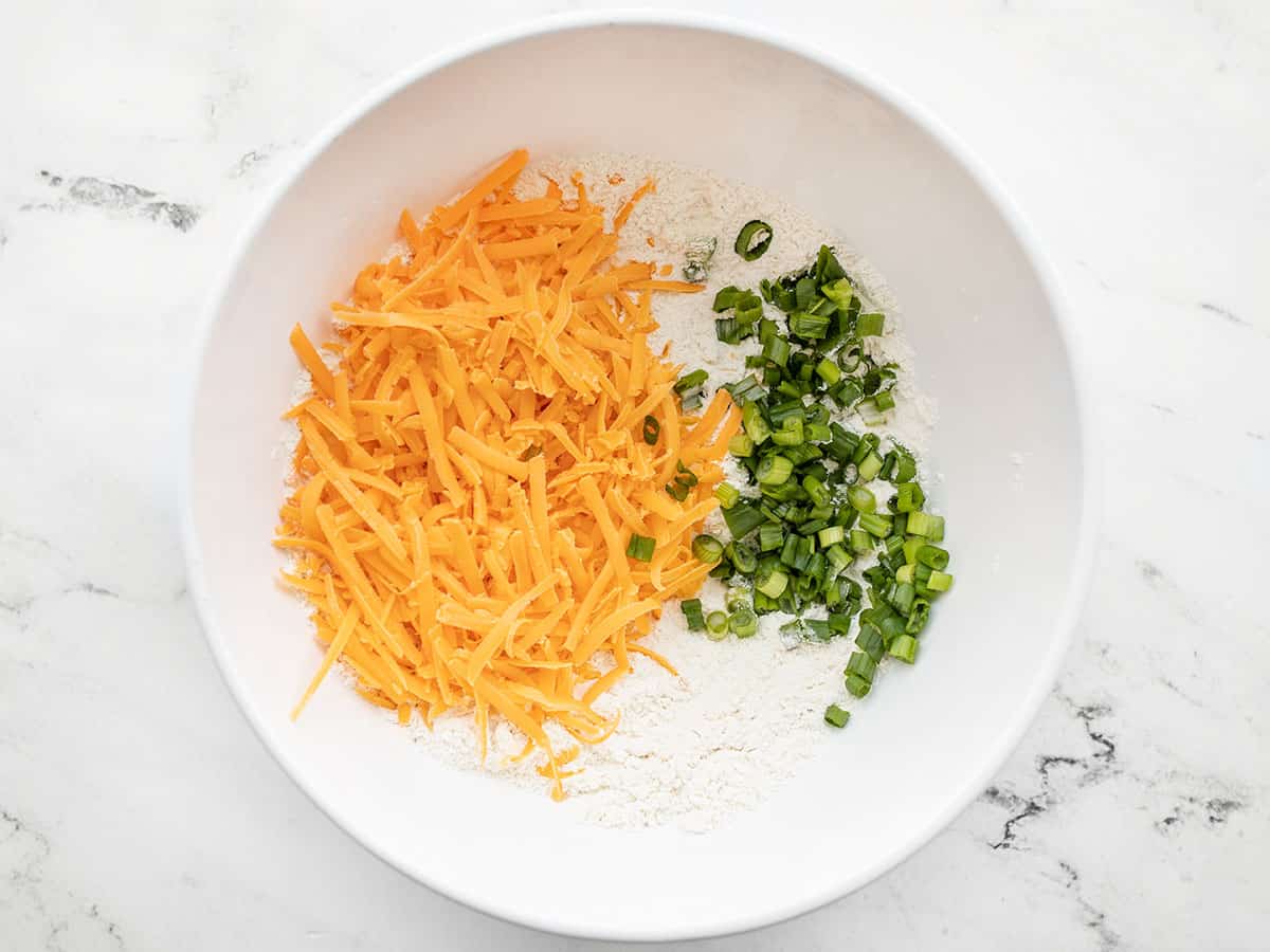 shredded cheddar and sliced green onions added to the bowl