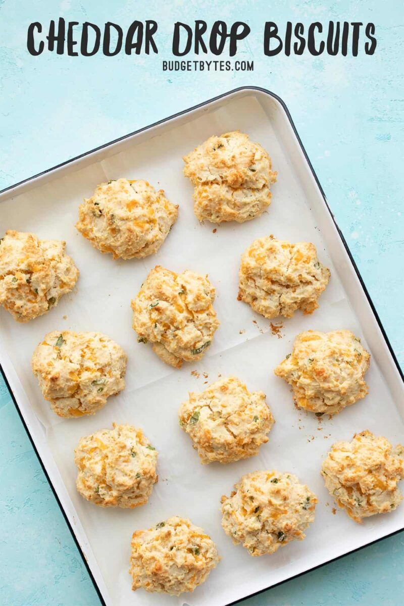 Cheddar drop biscuits on a baking sheet, title text at the top