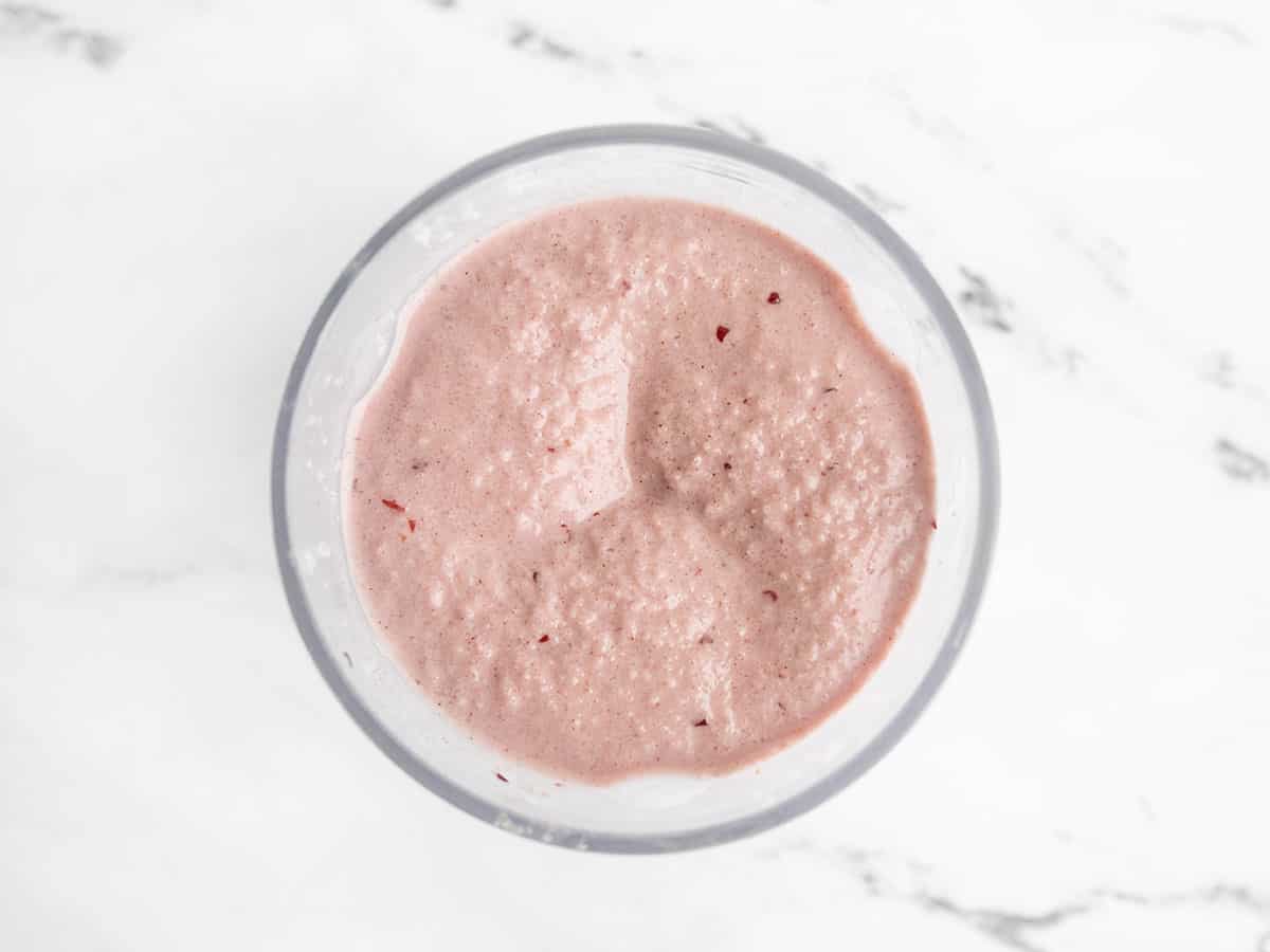 Looking down into a blender with a blended cherry almond smoothie