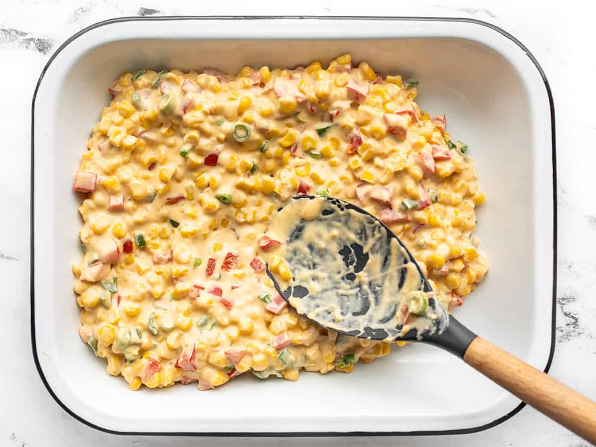 Hot corn dip being spread into a baking dish