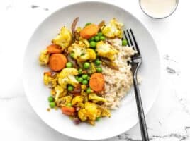 Overview of curry roasted vegetable bowls with lemon tahini dressing on the side