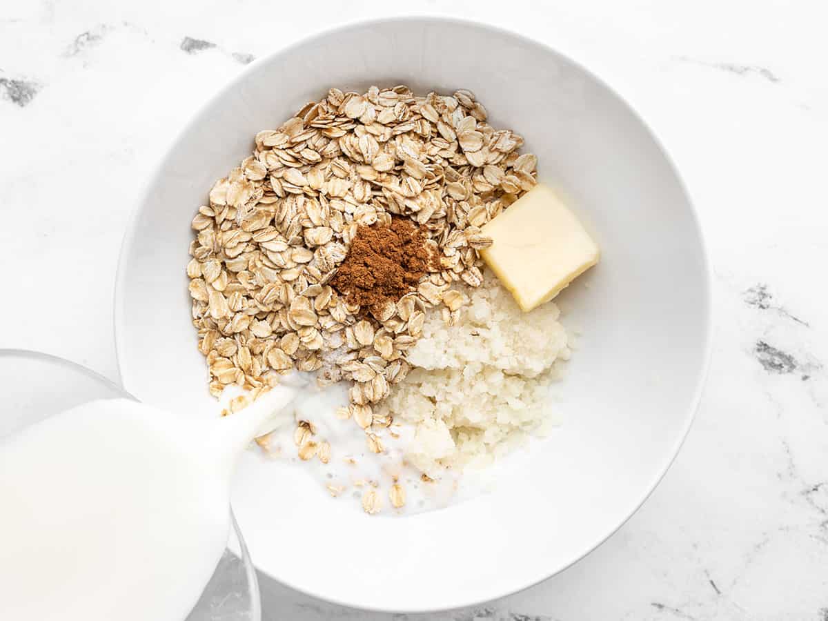 Cauliflower oatmeal ingredients in a bowl, milk being poured in