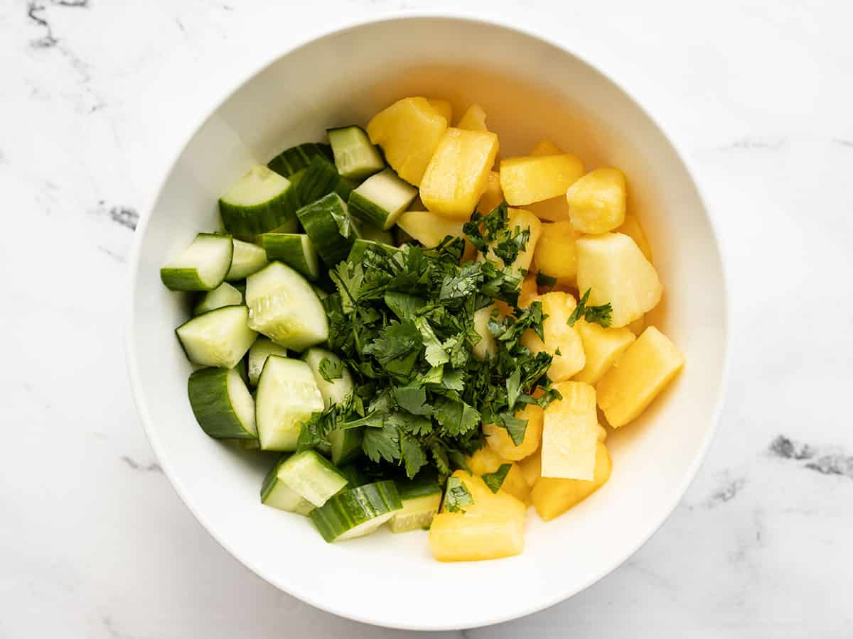 Cucumber, pineapple and cilantro in a bowl