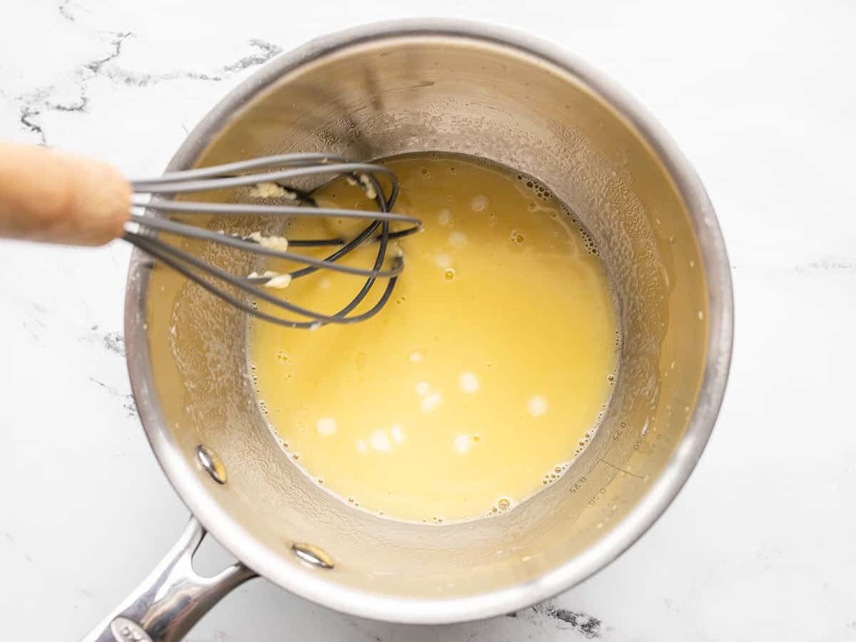 half melted butter in the sauce pot with a whisk