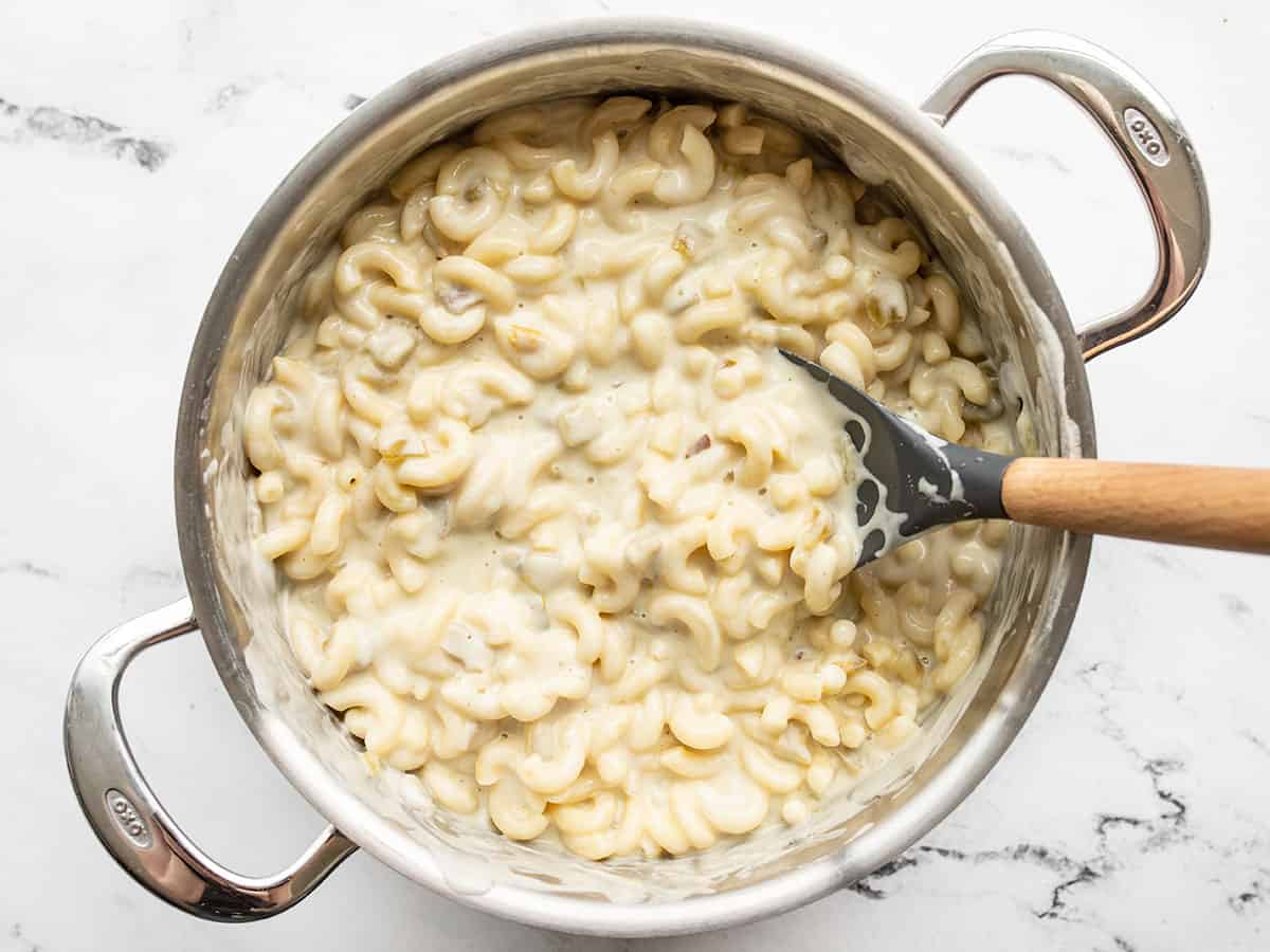 finished green chile mac in a pot with a spatula