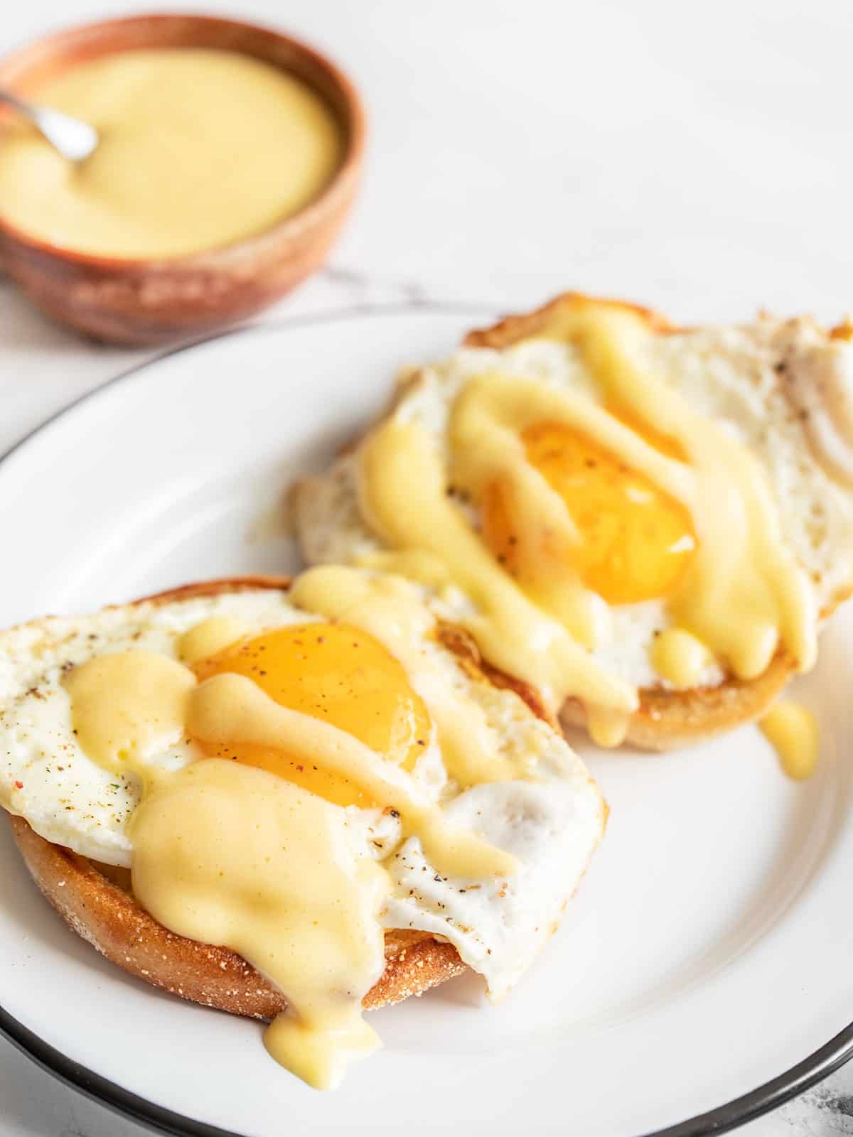 two eggs on English muffins drizzled with hollandaise sauce