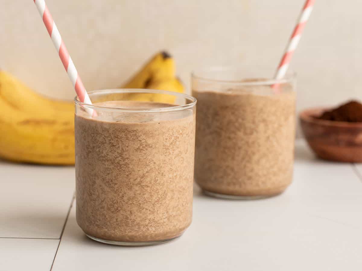 Two chocolate coffee smoothies in small glasses with straws