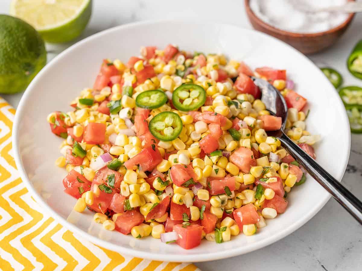 side view of a bowl full of fresh sweet corn salsa