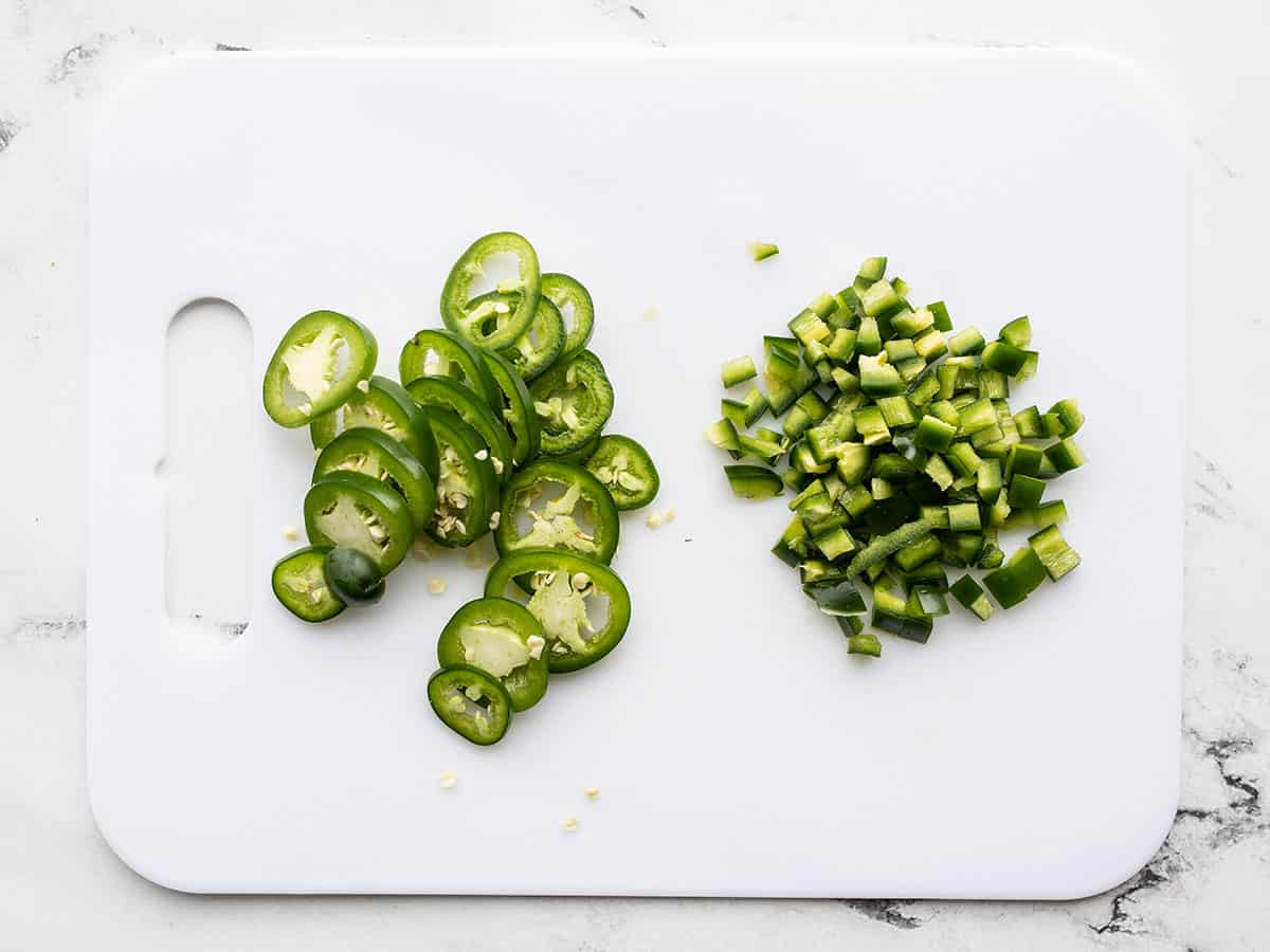 Diced and sliced jalapeño on a cutting board