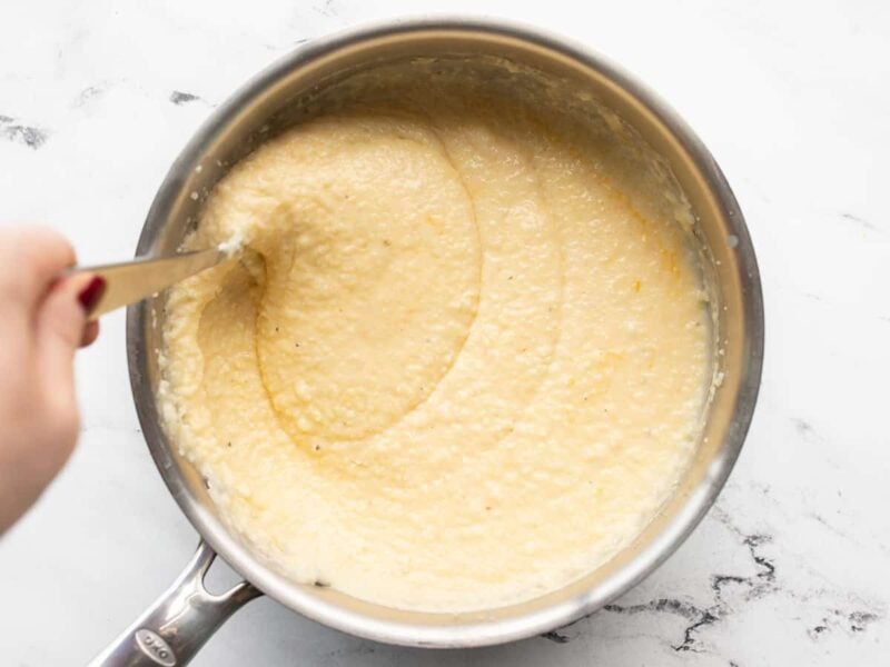 finished cheese grits being stirred in the pot