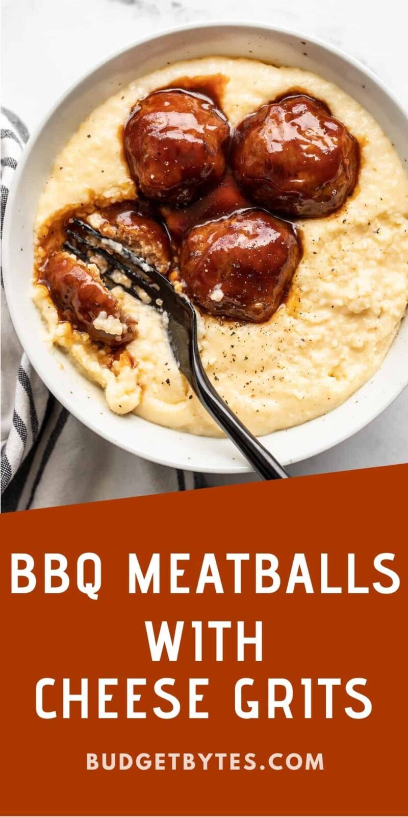 A fork cutting into a bbq meatball on a bed of cheese grits