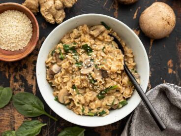 overhead view of a bowl full of savory oatmeal with ingredients on the sides