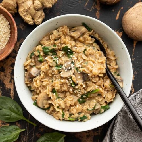 overhead view of a bowl full of savory oatmeal with ingredients on the sides