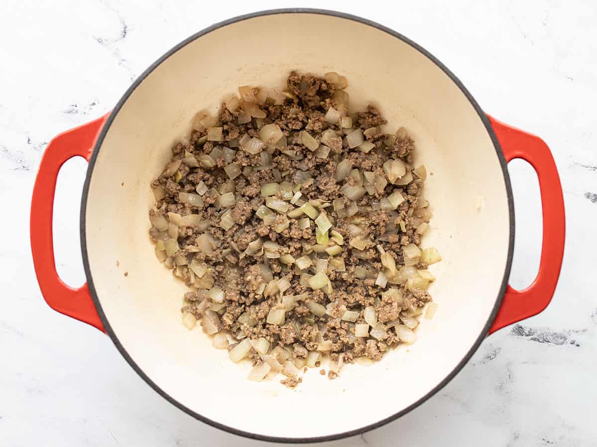 browned ground beef in the pot with onion and garlic