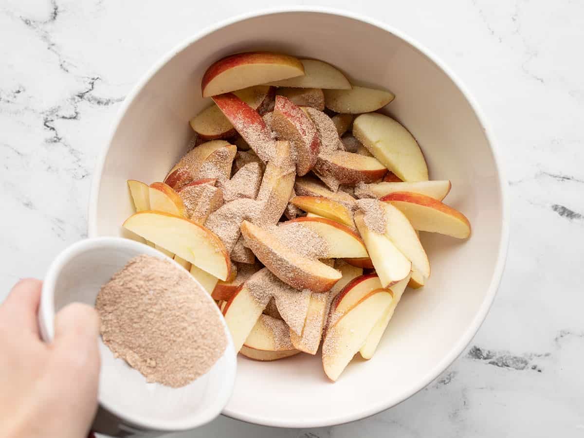 Seasoning being sprinkled over the apples