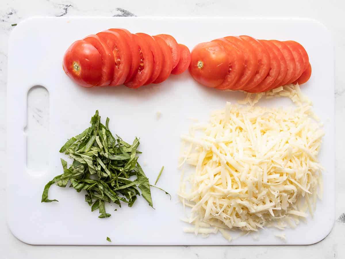 Prepped pizza toppings on a cutting board