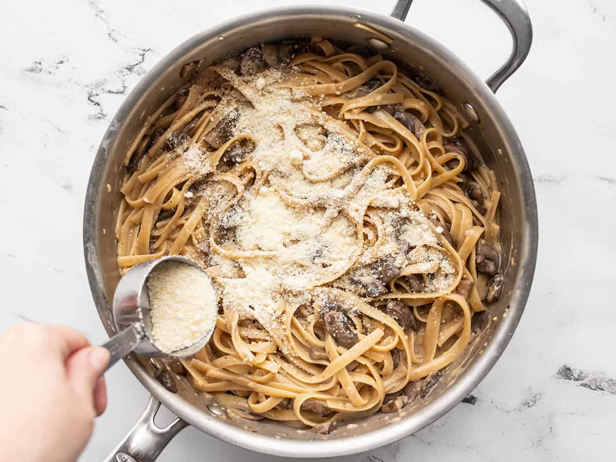 Parmesan being sprinkled over the pasta