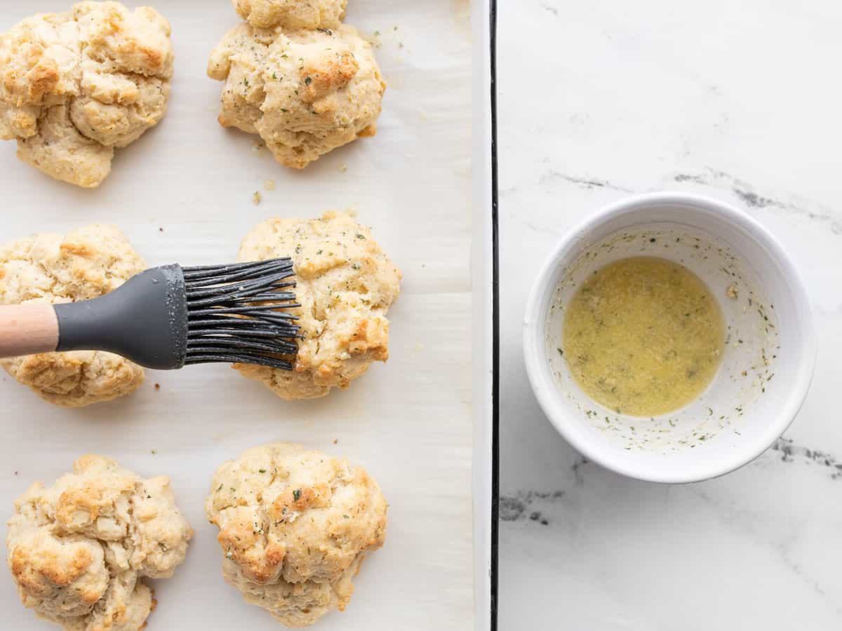 ranch butter being brushed over drop biscuits