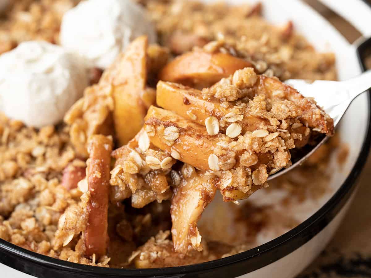 close up of apple crisp being scooped out of the baking dish