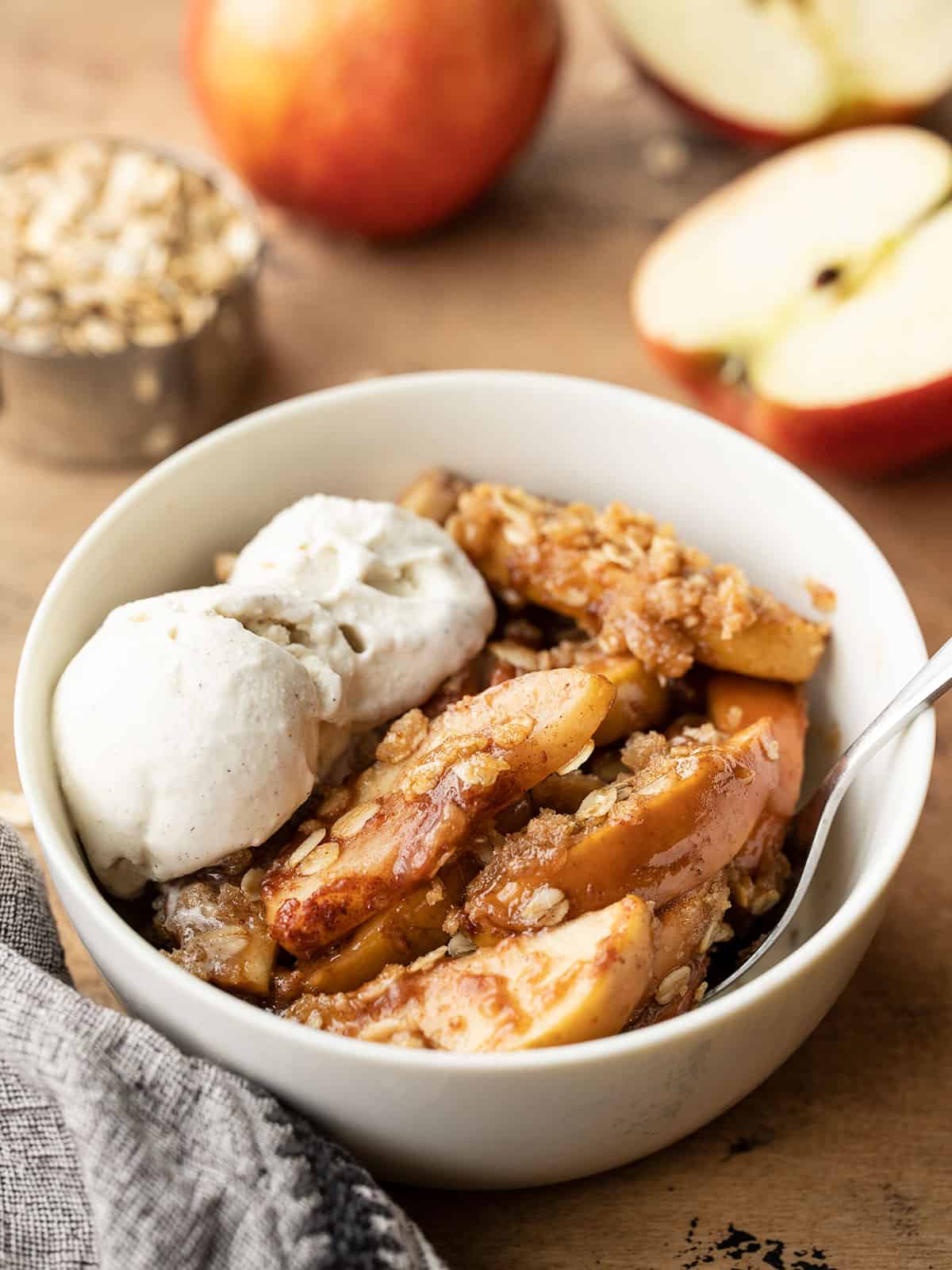 apple crisp in a bowl topped with ice cream