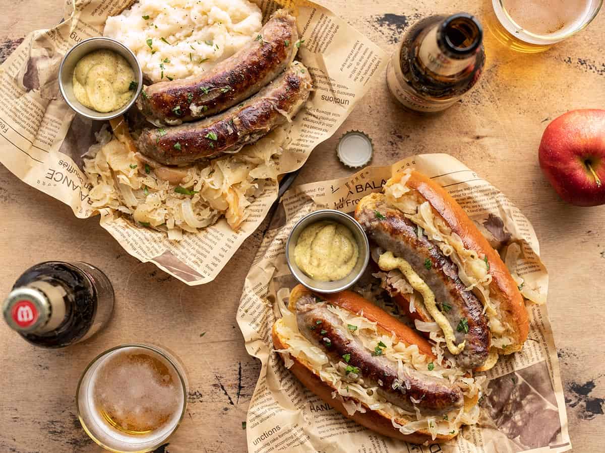 bratwurst and sauerkraut on plates with beer on the sides