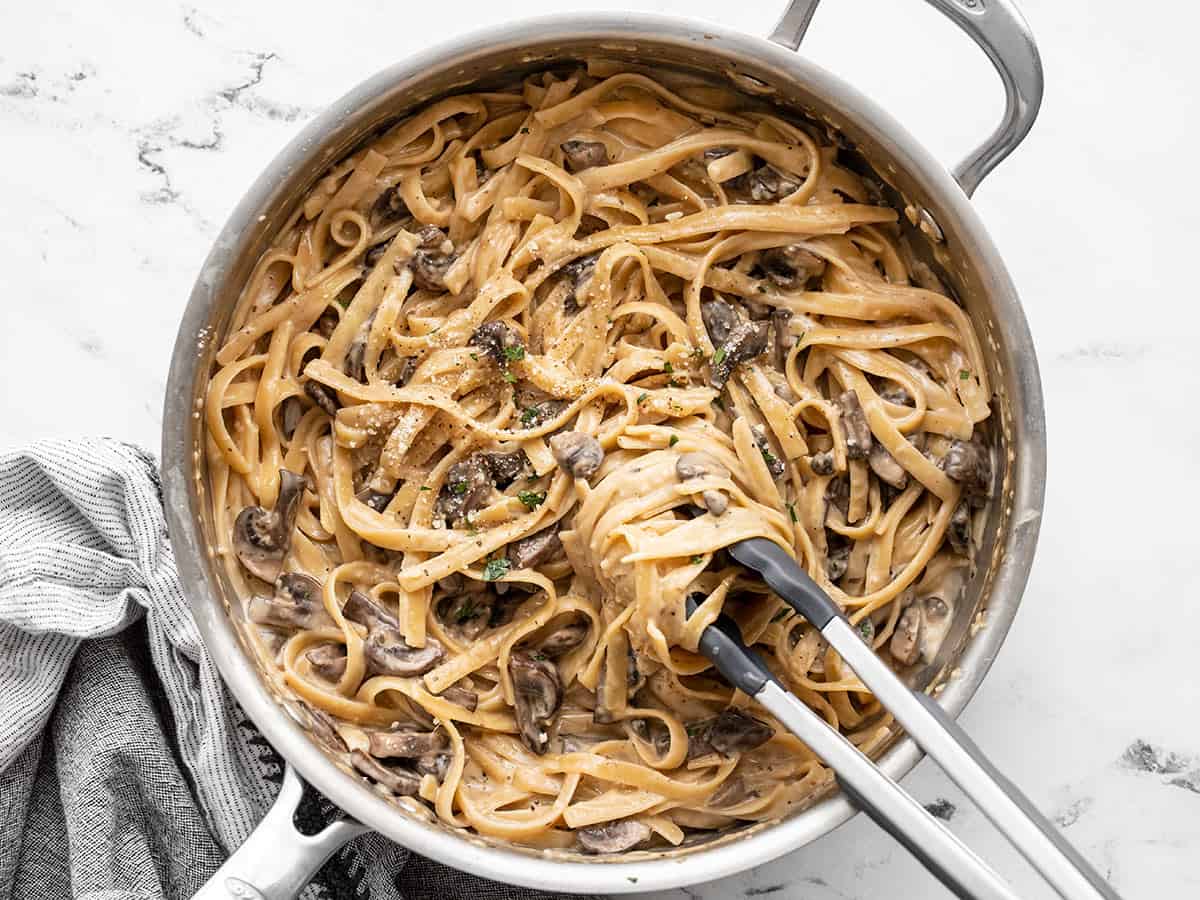 pasta twirled around tongs in the skillet