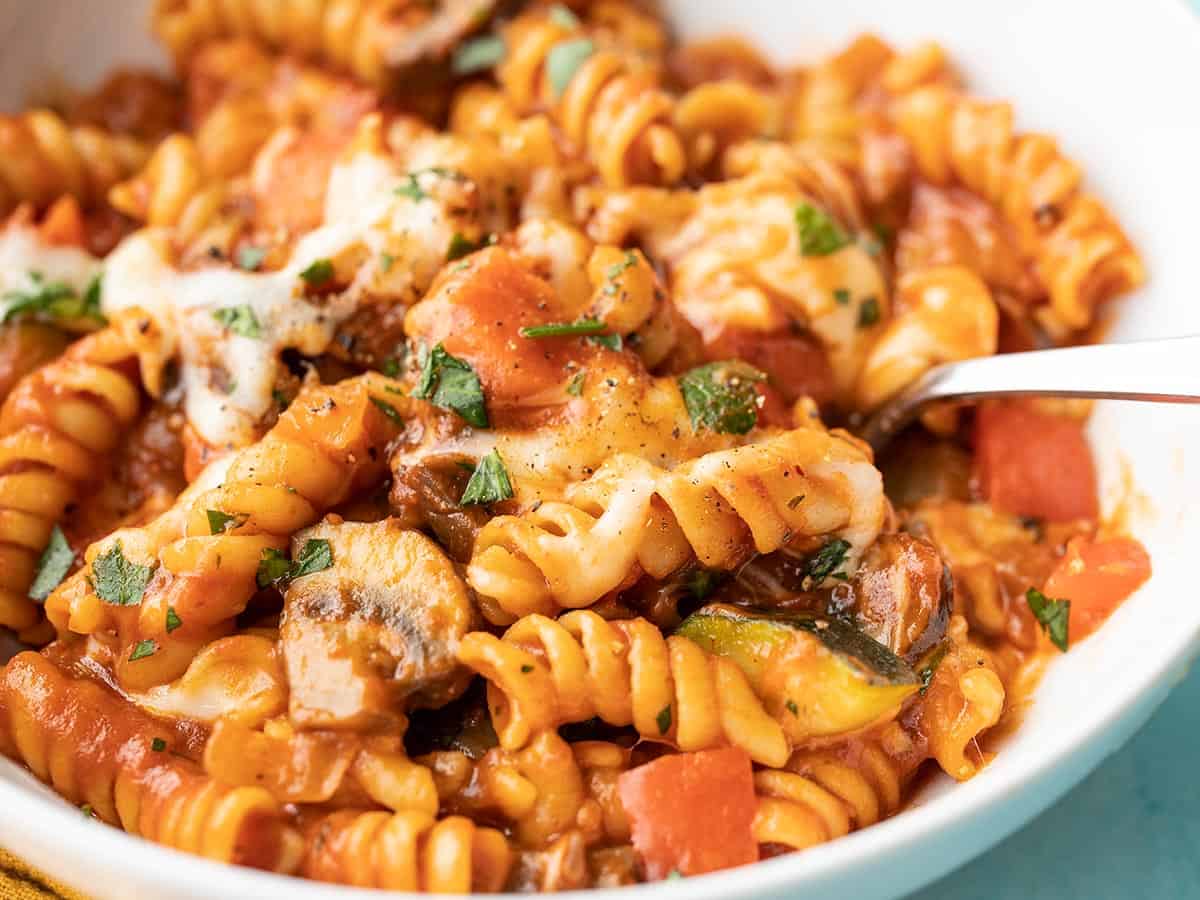 Close up side view of a bowl of veggie pasta with cheese