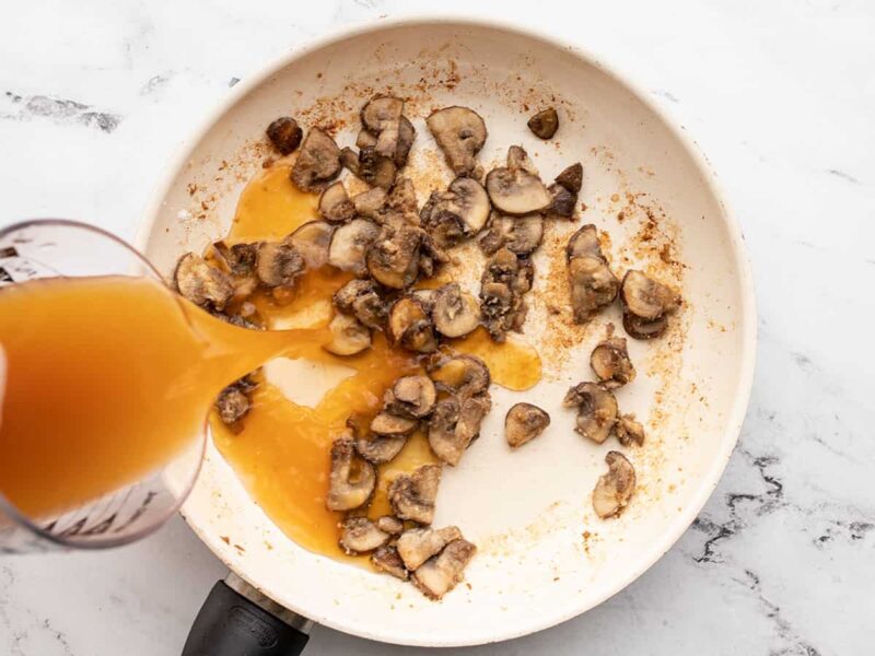 Broth being poured into a skillet