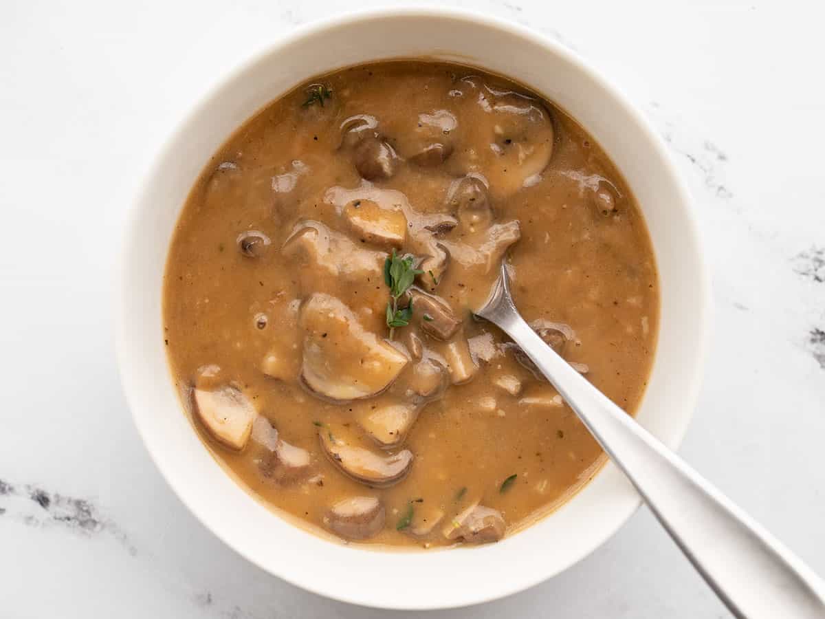 mushroom herb gravy in a bowl with a spoon