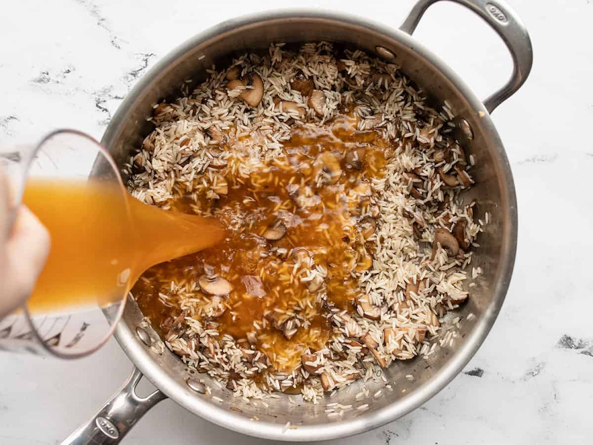 Broth being poured into the pan