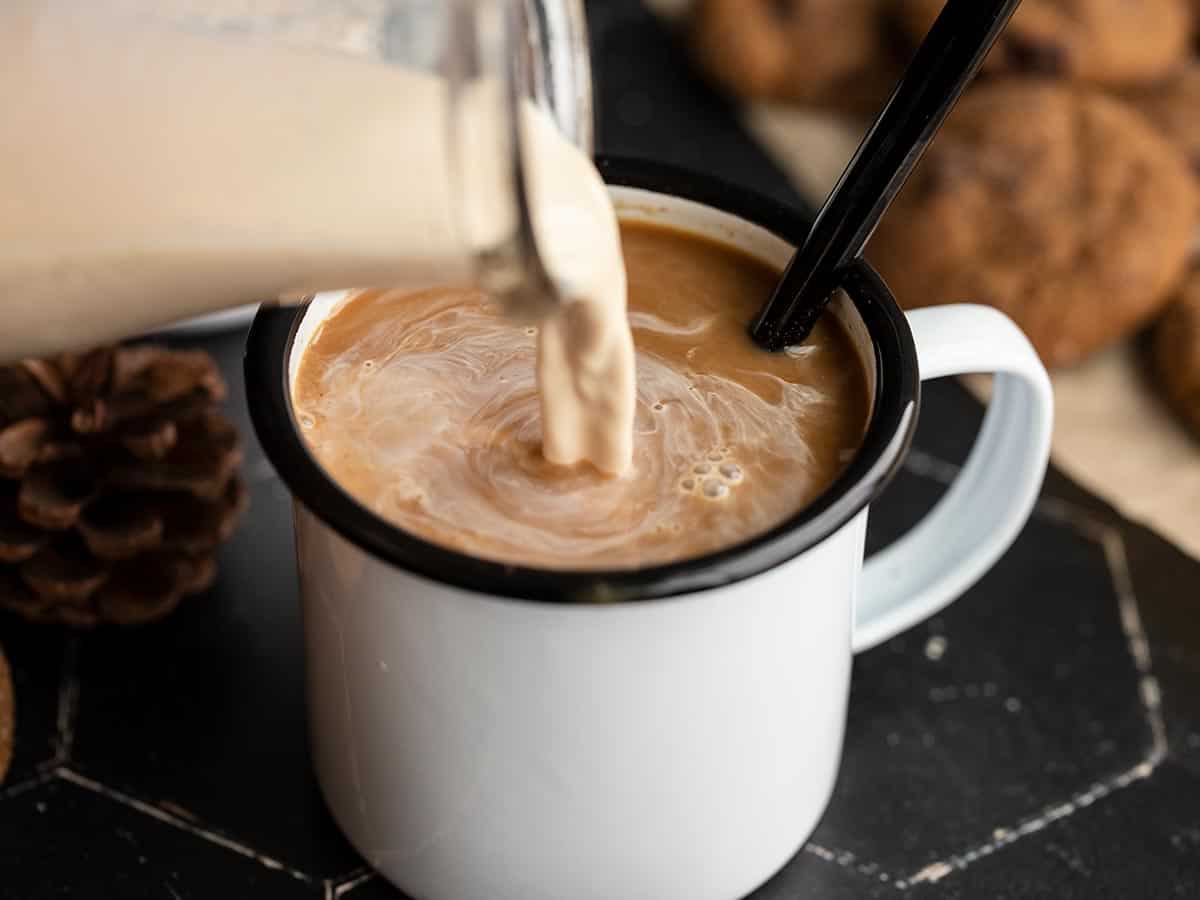 creamer being poured into a cup of coffee