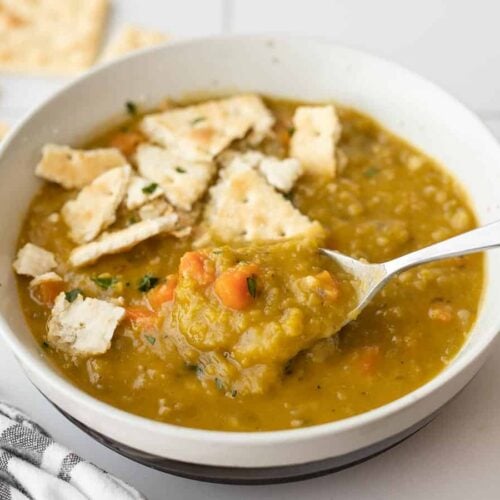 Thick split pea soup on a spoon in the soup bowl