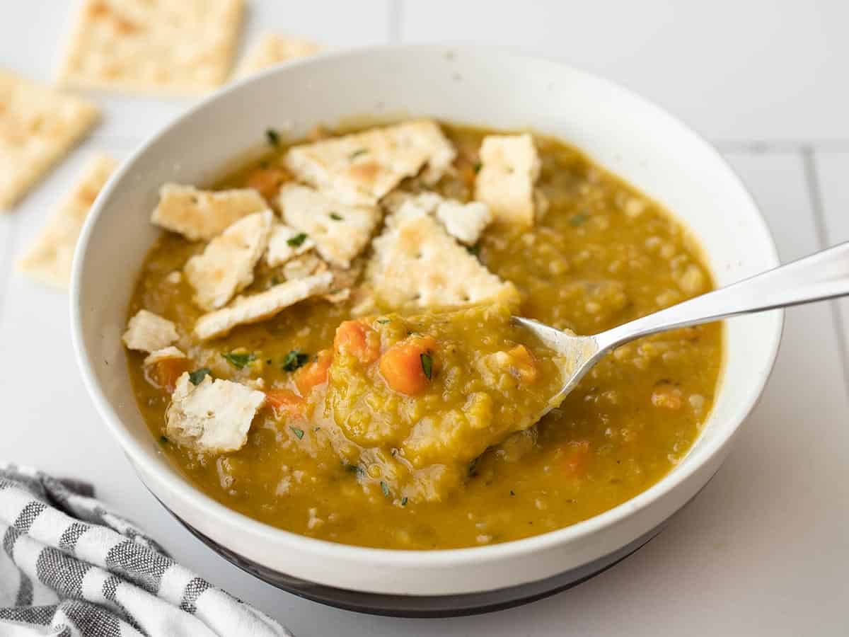 Thick split pea soup on a spoon in the soup bowl