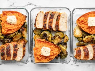 lineup of meal prep containers with chicken, brussels sprouts, and sweet potatoes