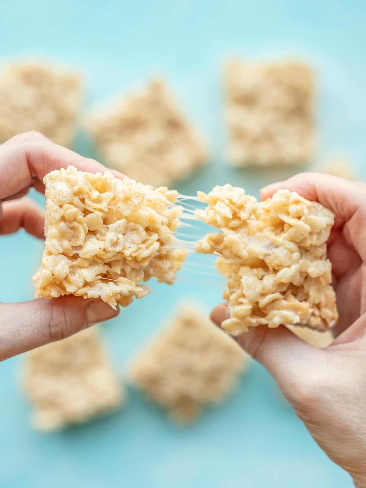 A hand pulling apart a rice krispie treat