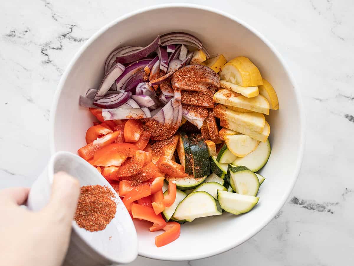 seasoning being added to the vegetables