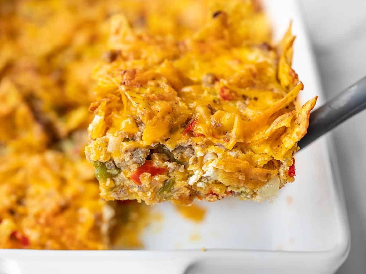 A spatula lifting a slice of breakfast casserole