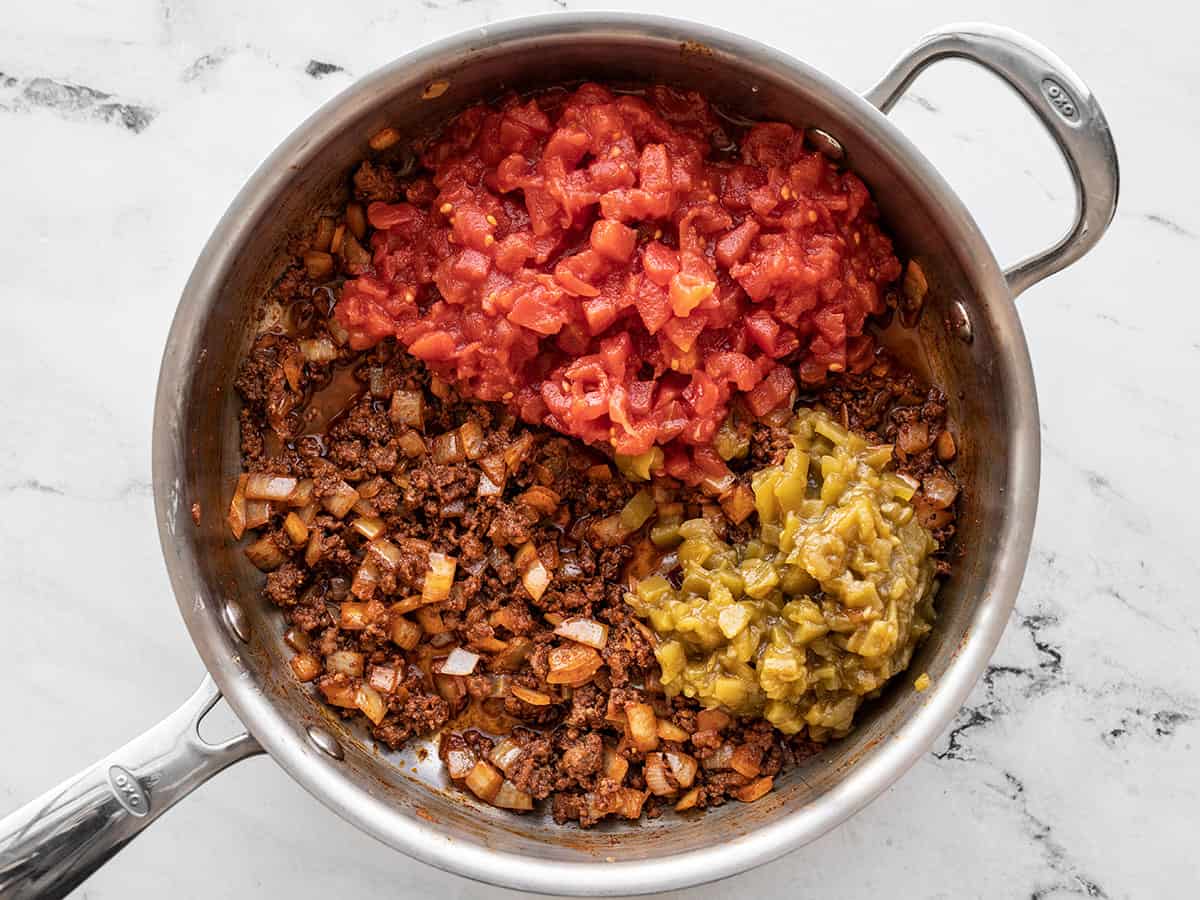 Diced tomatoes and green chiles added to the skillet