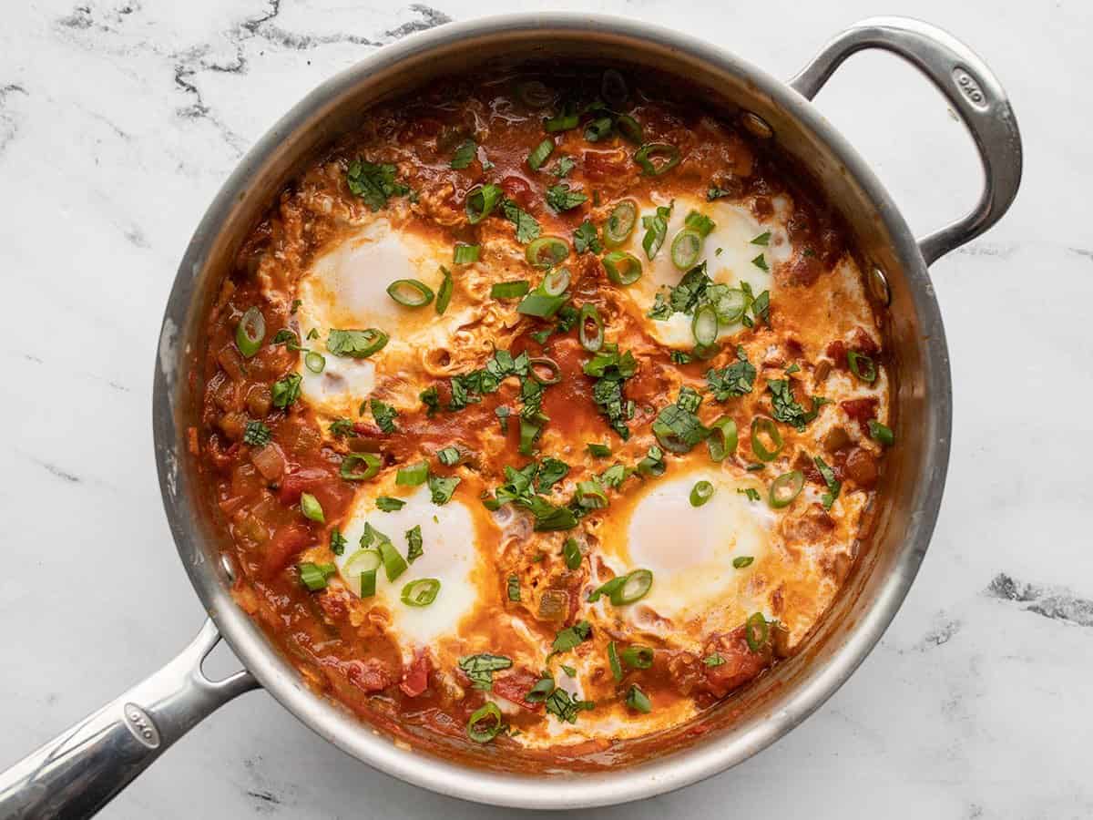 Poached eggs garnished with green onion and cilantro.