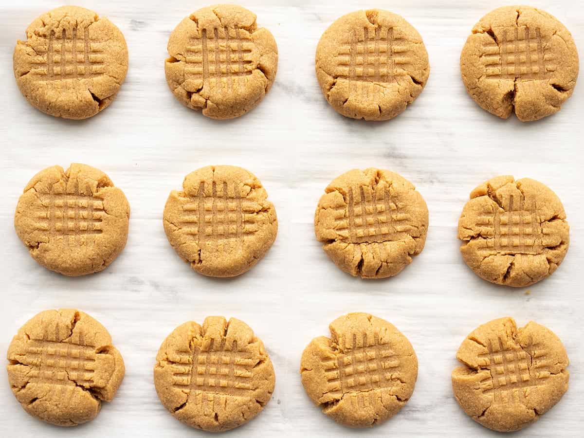 flourless peanut butter cookies lined up on a baking sheet.