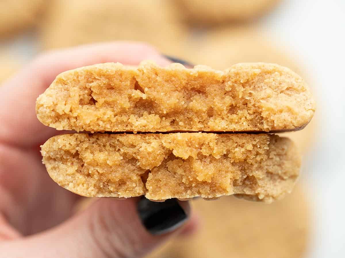 a peanut butter cookie broken in half facing the camera close up.