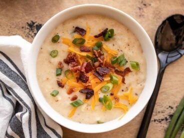 overhead view of a bowl of loaded potato soup with toppings.