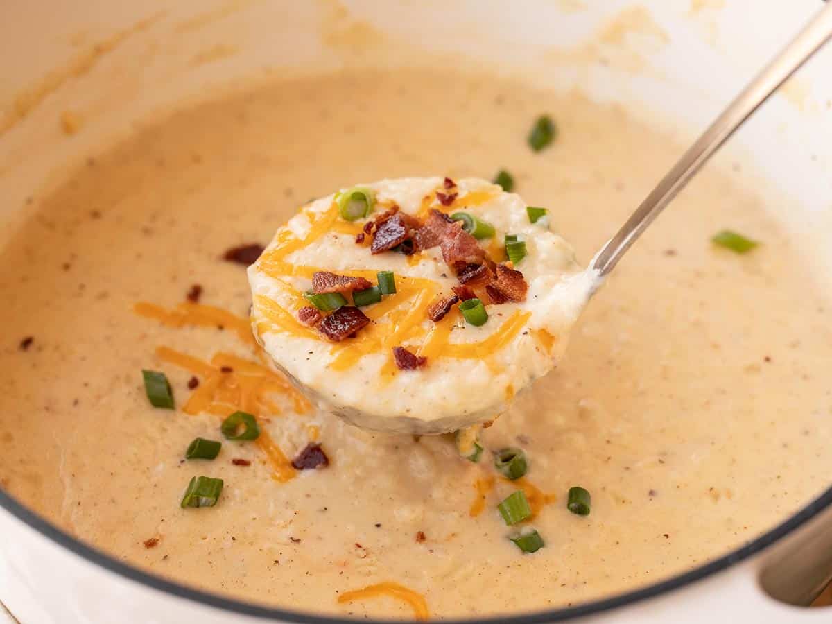 A ladle of potato soup being lifted from the pot.