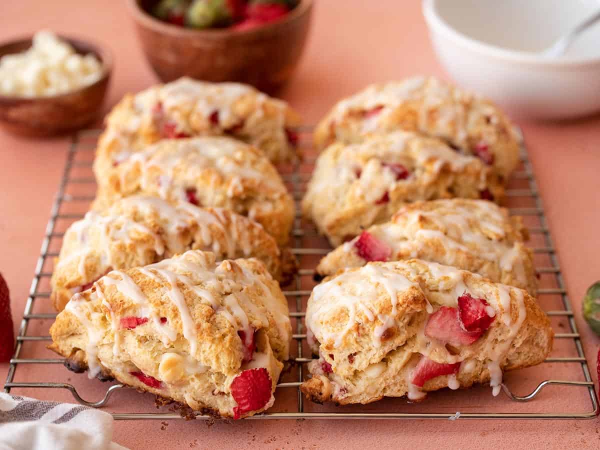 Side view of glazed strawberry scones on a cooling rack