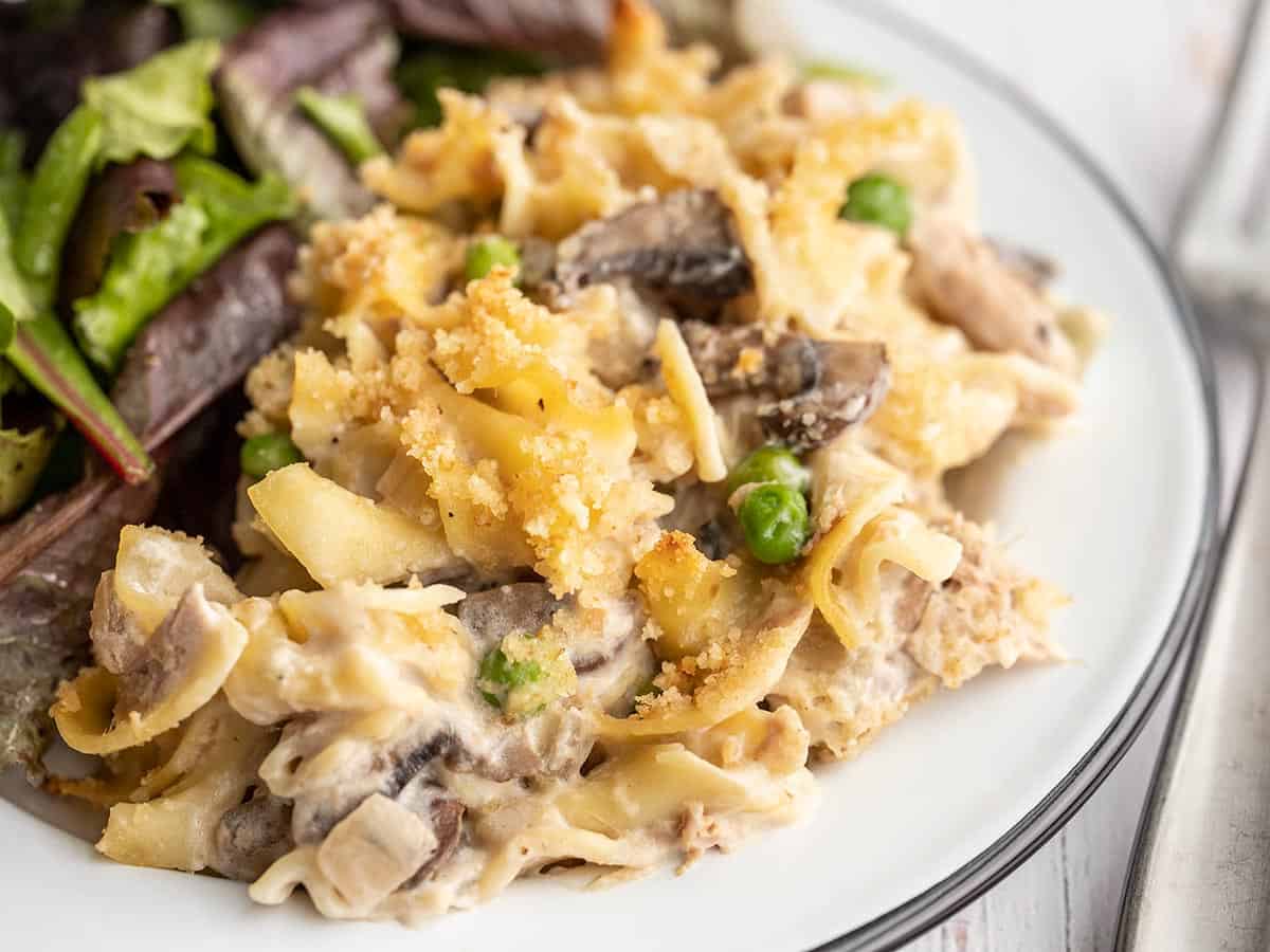 close up of tuna noodle casserole on a plate with salad