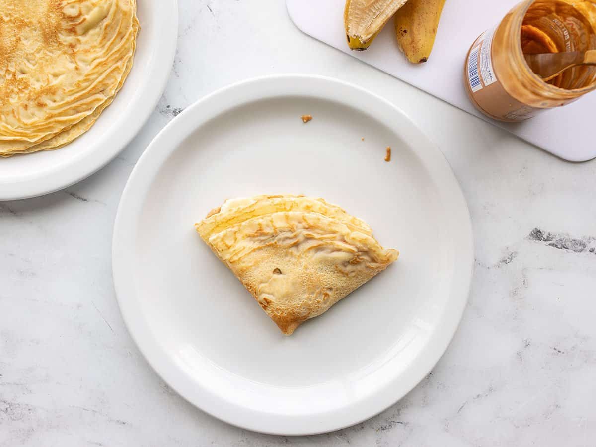 Filled and folded crepe on a plate.