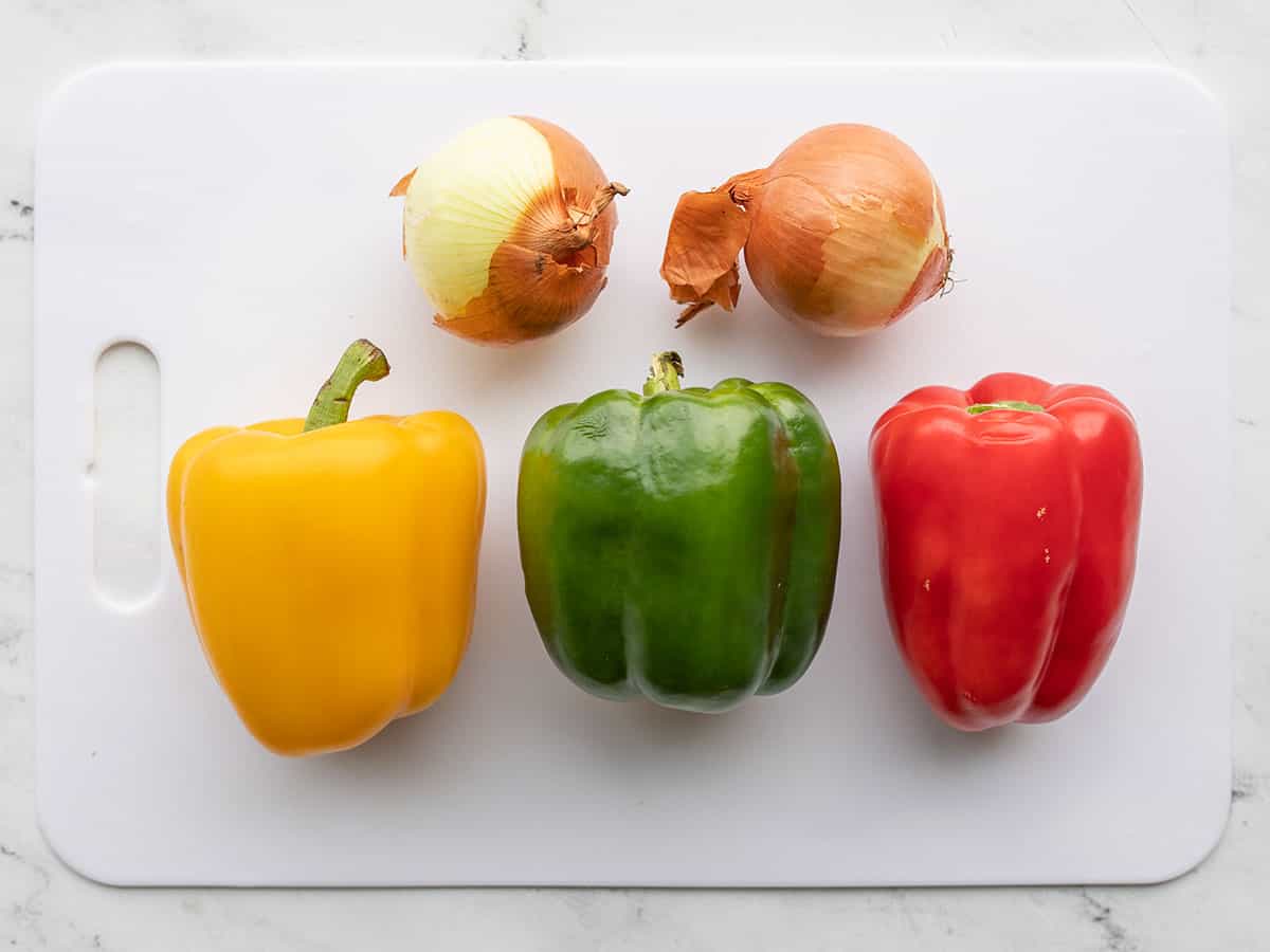 Vegetables for chicken fajitas on a cutting board.