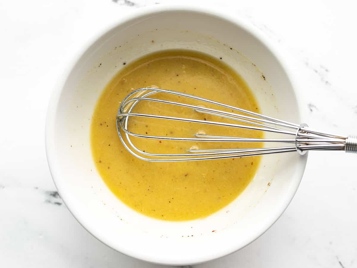 Whisked lemon Dijon vinaigrette in a bowl.