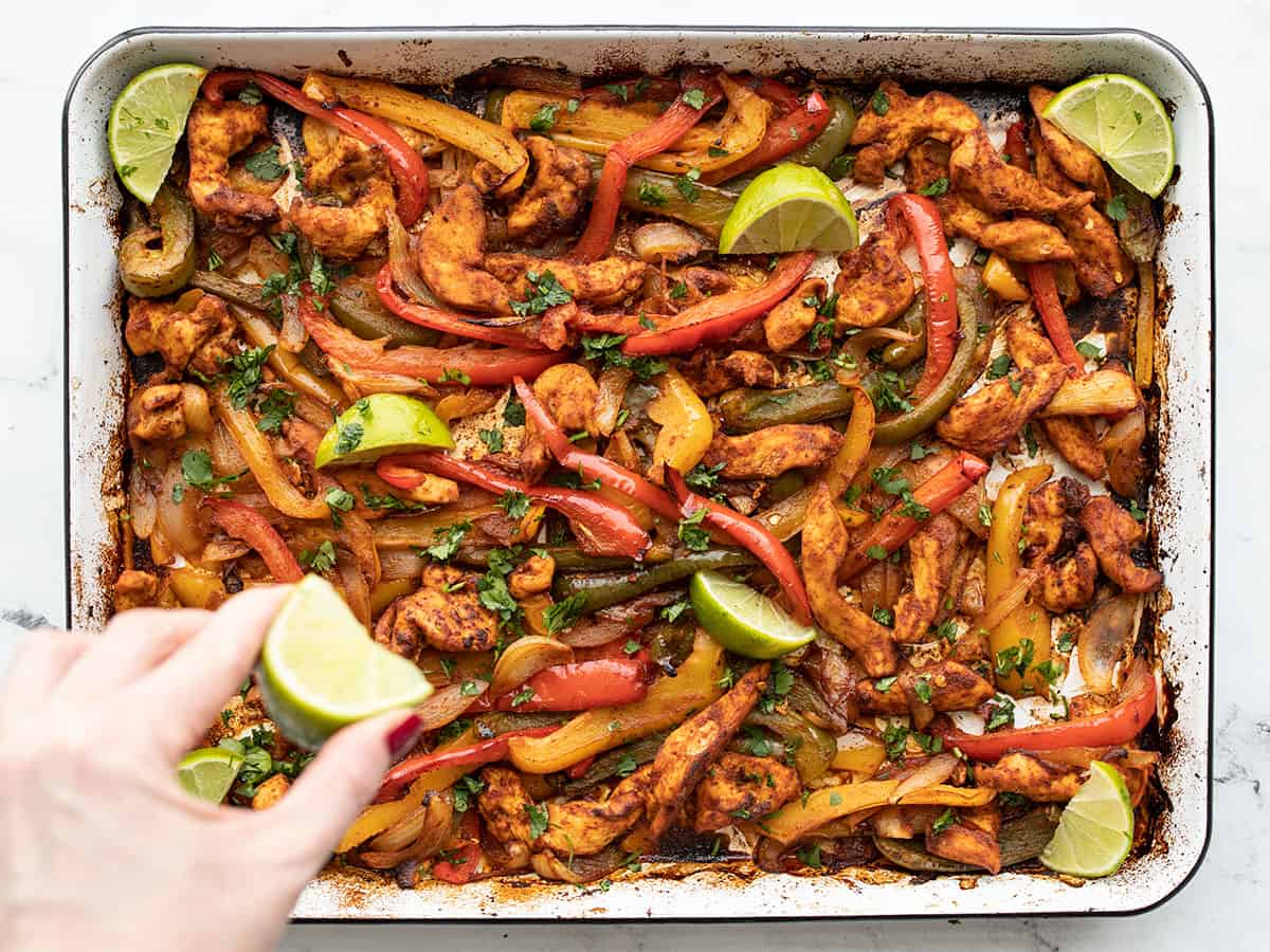 lime juice being squeezed over the chicken and vegetables